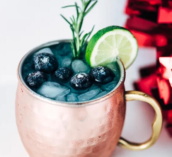 Meteor Shower Mule - Similar to a traditional mule, we start with vodka, but then we add blue curacao, lime juice, and ginger beer and serve it in a copper mug, topped with a lime wheel and frozen blueberries.