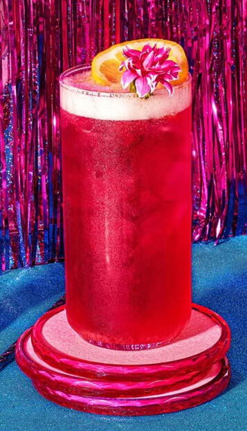 Cosmic Cosmo - This cosmo is truly out of this world. We expertly mix vodka, orange liqueur, lime juice, and cranberry juice, which is then shaken. And finally, a mesmerizing swirl of edible glitter is added before being topped with an orange wheel.